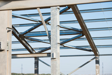 Steel frame workshop is under construction against a blue sky