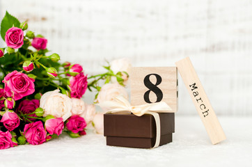 March 8 date on a wooden calendar and rose on a white background. Greeting card for 8 March Woman's Day.