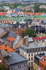 Fototapeta na wymiar Aerial view of beautiful buildings of Riga Old Town from Saint Peter's church on cloudy, foggy and rainy day, Riga, Latvia. Soft selective focus