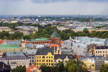Fototapeta premium Aerial view of Powder Tower, now part Of Latvian War Museum and Riga Old Town from Saint Peter church on cloudy, foggy and rainy day, Riga, Latvia. Soft selective focus
