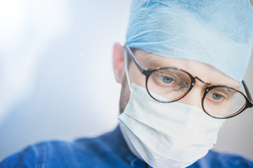 bottom view of a young surgeon looking at camera. Surgical operation in the hospital.