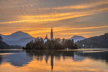 Scenic Lake bled with church under orange morning sky