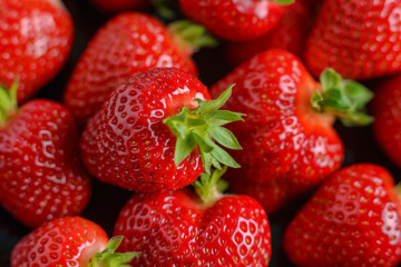 Strawberry closeup. Macro image of fresh strawberries on dark background