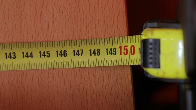 Using measuring tape to check dimensons of furniture