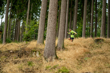 A young athlete in barefoot shoes runs down the mountain. Mountain run. Cross Country Running. Individual sports
