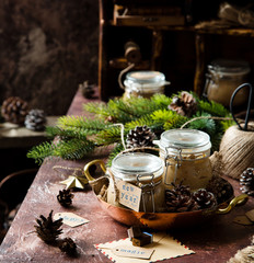 homemade liver pate in glass jars on rustic table with fir tree branches, toys