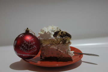 A piece of cake and a Christmas red ball.