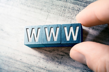 The Word WWW On Wooden Blocks And Arranged By Male Fingers On A Table
