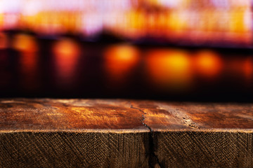Empty Wooden Table with a View of Blurry Evening City. Backdrop for Product Placement