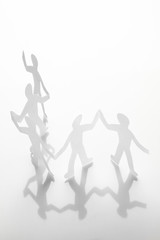 Chain of paper men holding hands from humanity and kindness