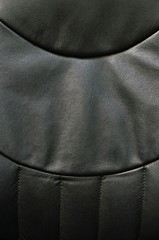Abstract image black vinyl seat cover in vertical format with slight shadows and textures.