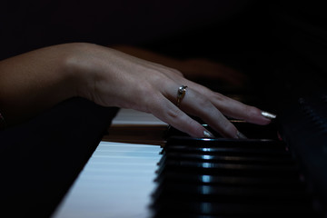 la mano de una mujer tocando el piano - obrazy, fototapety, plakaty