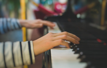 Little girl is playing the grand piano.