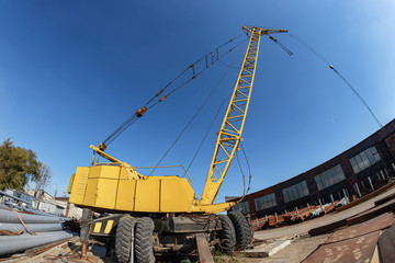 Wheeled yellow truck crane for loading heavy metal
