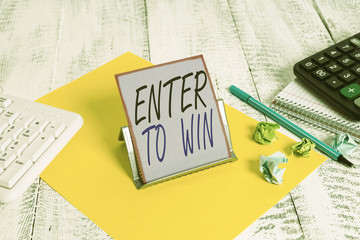 Fototapeta premium Word writing text Enter To Win. Business photo showcasing exchanging something value for prize or chance of winning Notepaper stand on buffer wire in between computer keyboard and math sheets