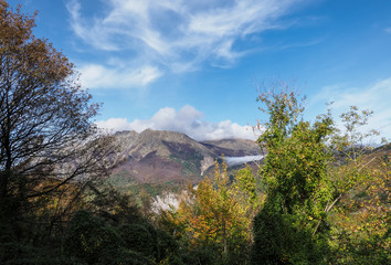 Fototapeta premium View over Sassalbo, in the comune of Fivizzano, Lunigiana, Italy. Near Cerreto pass in the Apennine Mountains. Autumn colours and fog.