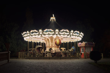 Old fashioned carousel backlit in a night park, autumn background © Vladimir Kazimirov
