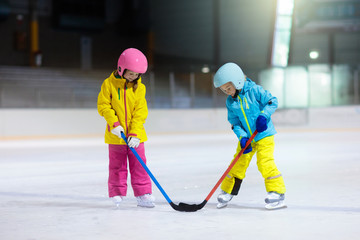 Children play ice hockey. Kids winter sport.