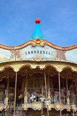 old carrousel in gold colors with lanterns on blue sky background