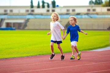 Child running in stadium. Kids run. Healthy sport.