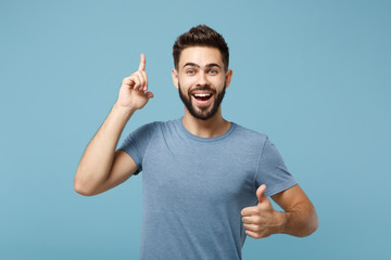 Young cheerful man in casual clothes posing isolated on blue wall background, studio portrait....