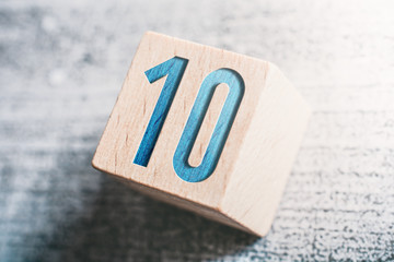 Number 10 On A Wooden Block On A Table - obrazy, fototapety, plakaty
