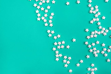Little white stars on mint background. Holiday concept. Flat lay, top view.