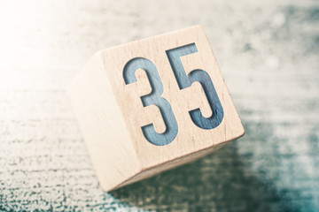 Number 35 On A Wooden Block On A Table