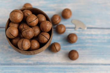 macadamia nuts and a metal key for opening nuts. nutritious and healthy snack.