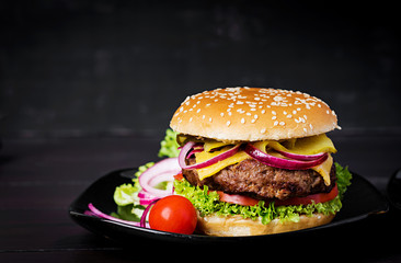 Big sandwich - hamburger burger with beef,  tomato, cheese, pickled cucumber and red onion.