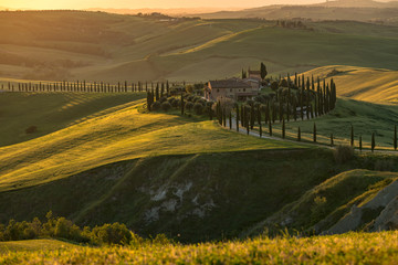 Naklejka premium Farma w Toskanii, Włochy, zielone wzgórza podczas zachodu słońca