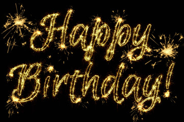 Celebration concept. Text Happy Birthday written sparkling sparklers isolated on black background. Overlay template for greeting card and any projects