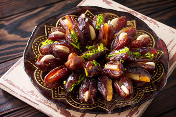 Dried dates stuffed with candied fruits and nuts on a rustic wooden table.