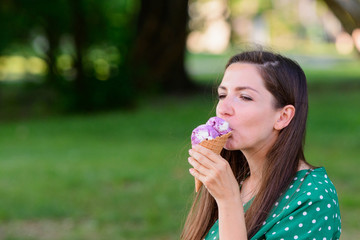 girl eating ice cream on a green background. place for an inscription. Portrait of a young urban woman with ice cream on a green background. girl eating ice cream in a green dress with white polka dot