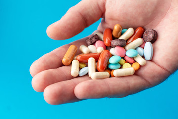 A handful of colored pills on the palm. Medical concept. Shopping at the pharmacy.