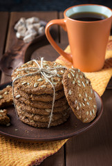 Oatmeal cookies and a cup of coffee on a wooden table.