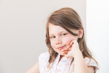 Fototapeta premium Smiling little Caucasian girl, close-up face portrait