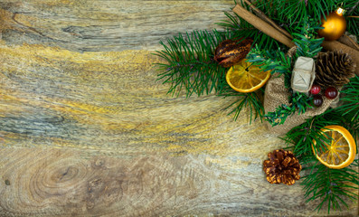 Holzbrett mit Tannenzweigen, getrockneten Orangen und Zimtstangen als weihnachtlicher Hintergrund
