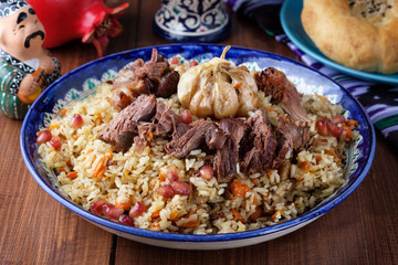 Homemade Uzbek pilaf from lamb served in cast iron cookware.