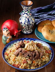Homemade Uzbek pilaf from lamb served in cast iron cookware.