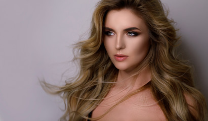 Fototapeta premium Gorgeous woman with a beautiful curly hair and professional makeup