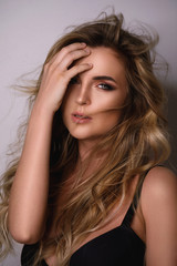 Fototapeta premium Gorgeous woman with a beautiful curly hair and professional makeup