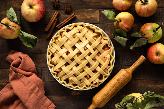 Apple pie with lattice top on wooden background, table top view. Rustic american apple pie