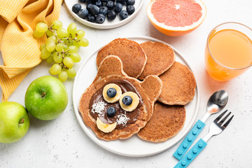 Funny cat pancakes with chocolate spread and banana for kids on a plate. Baby food, pancake food...