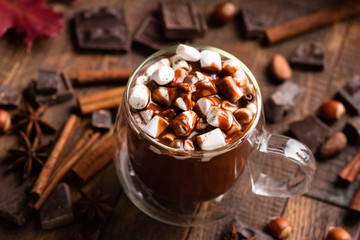 Mug of hot chocolate with marshmallows and cinnamon on a brown wooden table. Comfort food, Christmas beverage