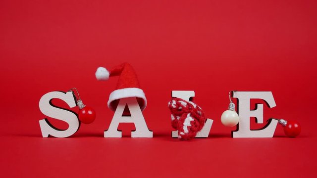 White letters form word sale on red background. Cute christmas elements on the inscription