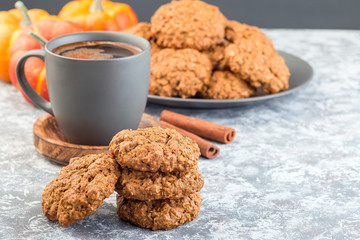 Spicy pumpkin and oatmeal cookies on the table and on a plate, with cup of coffee, horizontal, copy space