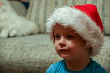 2011.01.01, Maloyaroslavets, Russia. A little boy wearing harlequin hat watching TV, blur and grain effect. Funny children.