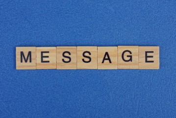 the word message of brown wooden letters lies on a blue table