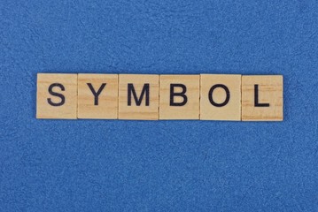 word symbol from brown wooden letters lies on a blue table